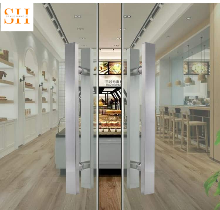 tay nắm cửa kính showroom – khách hàng thao tác mở cửa kính showroom bằng tay nắm thanh kéo 2026